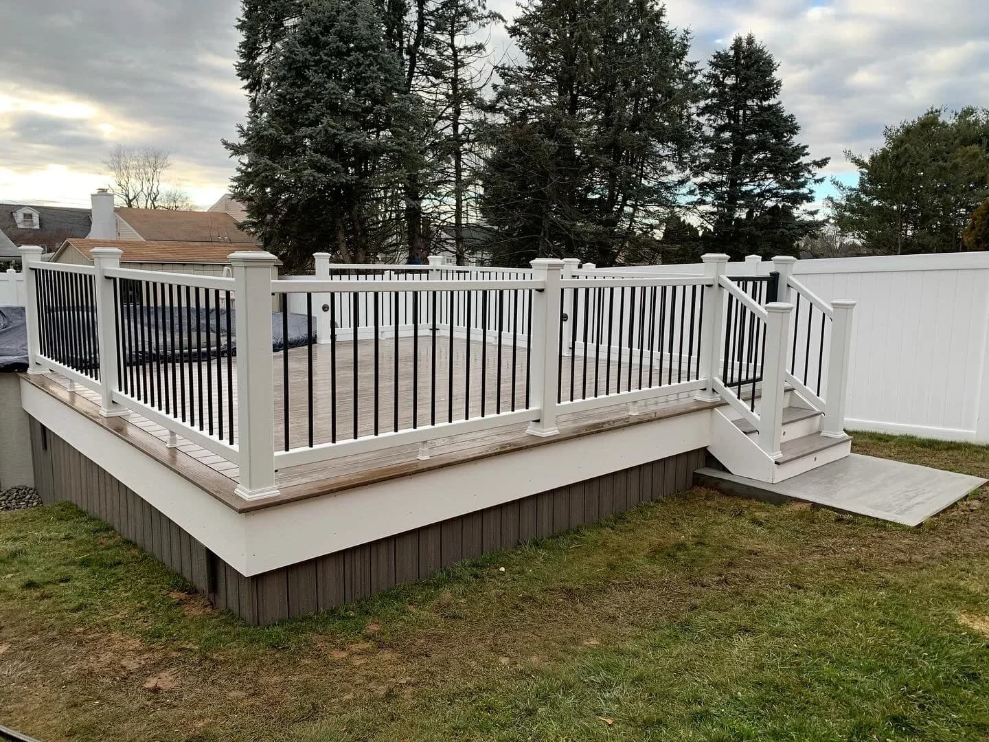White privacy fencing beside a completed deck