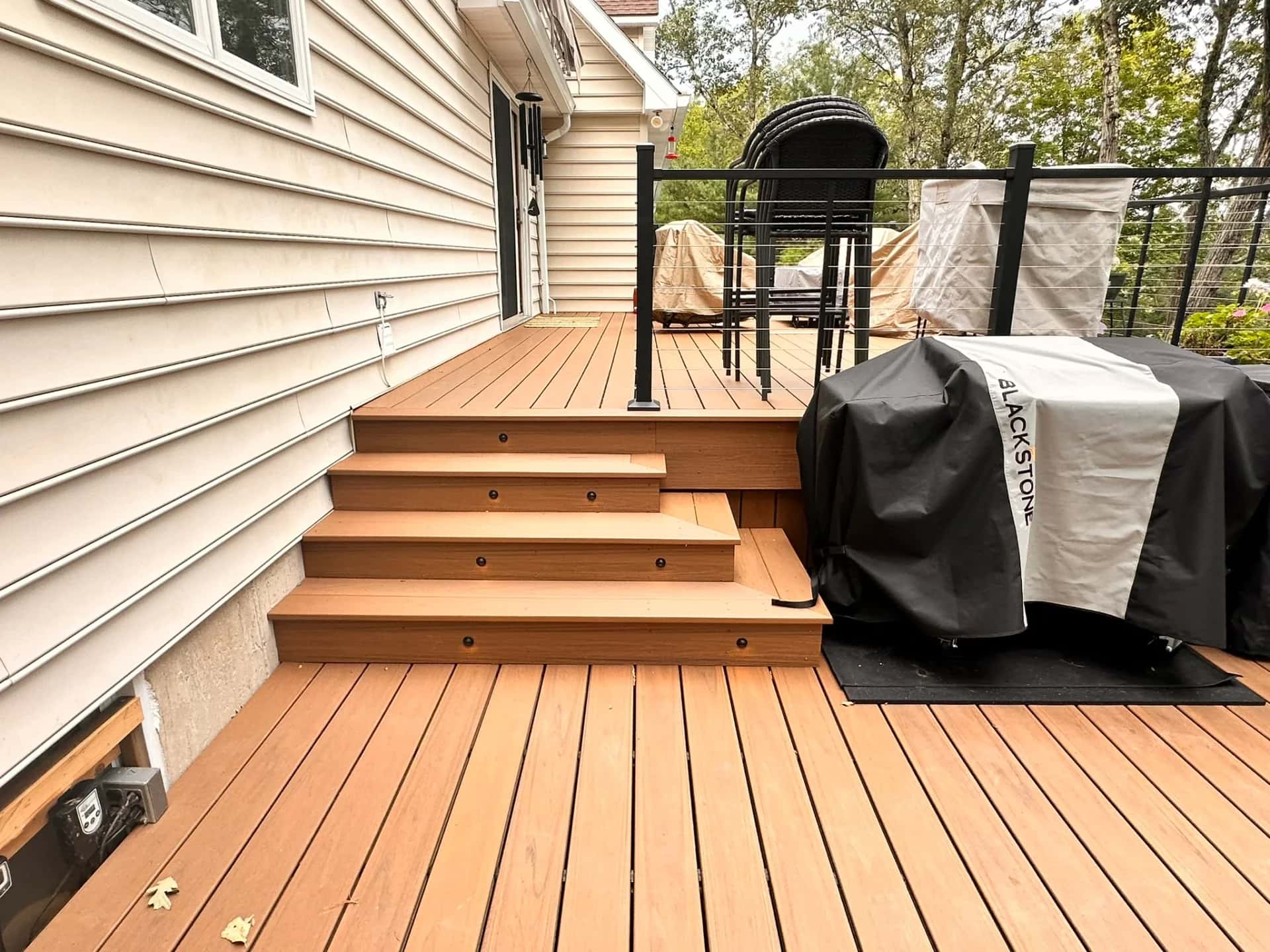 Composite deck with a cable railing system, LED stair lights and an outdoor grill station