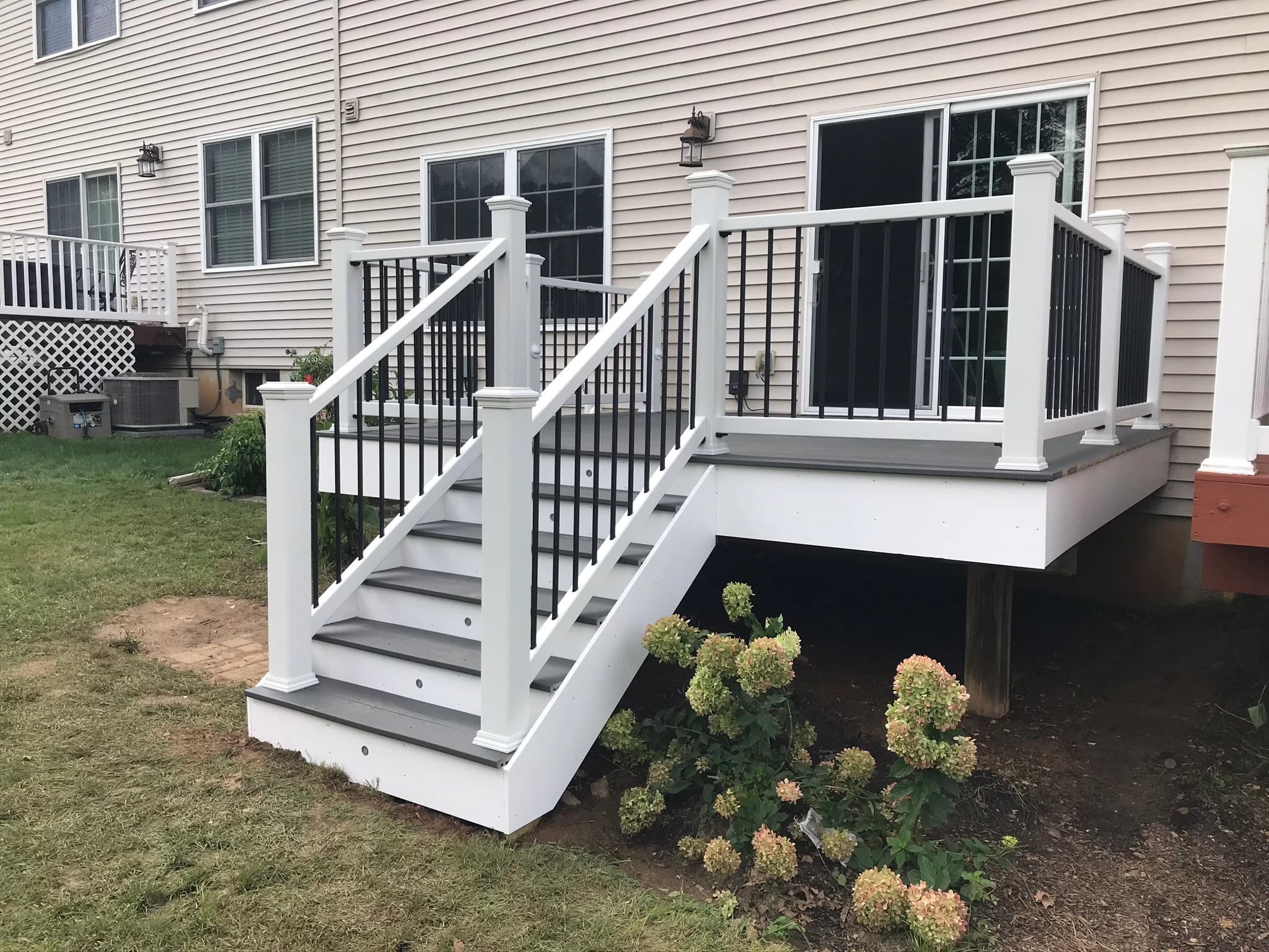Angled view of the stair, white fascia and dark railing infill.
