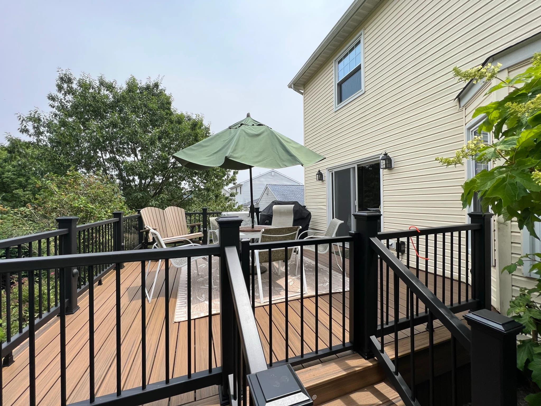 Brown deck boards, dark railings and the garden-side stair.